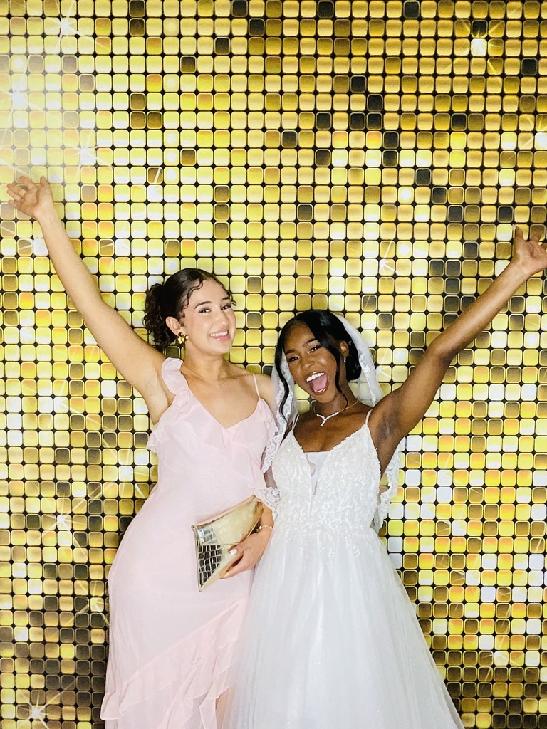 Mariée et demoiselle d’honneur célébrant devant le photobooth