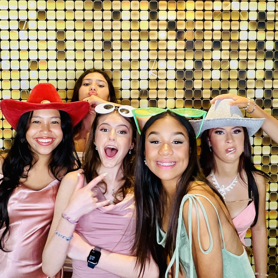 Invitées d’une quinceañera devant une toile de fond dorée